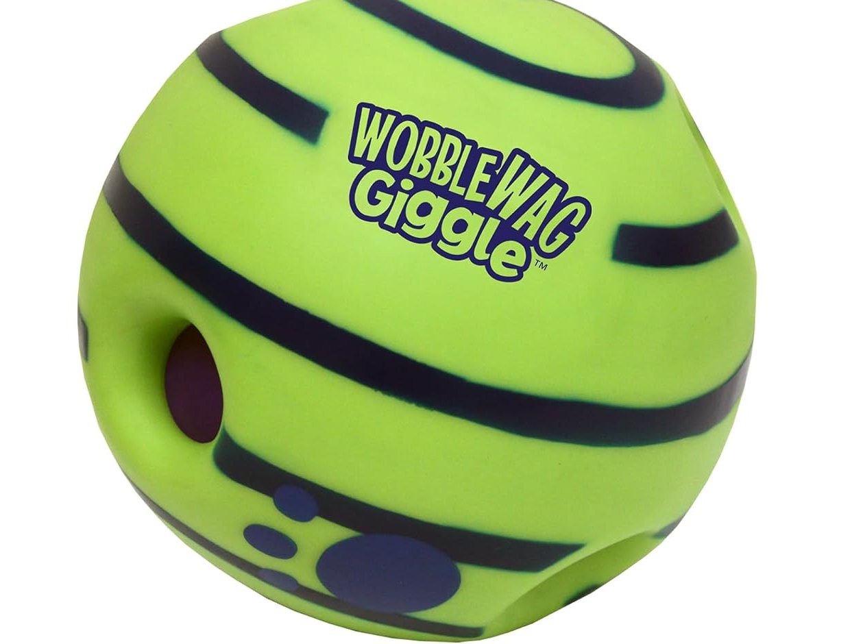 Close-up of the green Wobble Wag Giggle ball showing a clutch pocket and the giggle tube vent